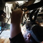 Cutting tabs off the Delica Colin is cutting brackets and tabs off so that the aluminum box will fit in the space under the van that used to house the rear heater core and AC.