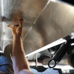 Dry Fitting the Aluminum Box that holds the Espar and Elgena. Colin is dry fitting the aluminum box under the van. The installation is tricky because space is limited.